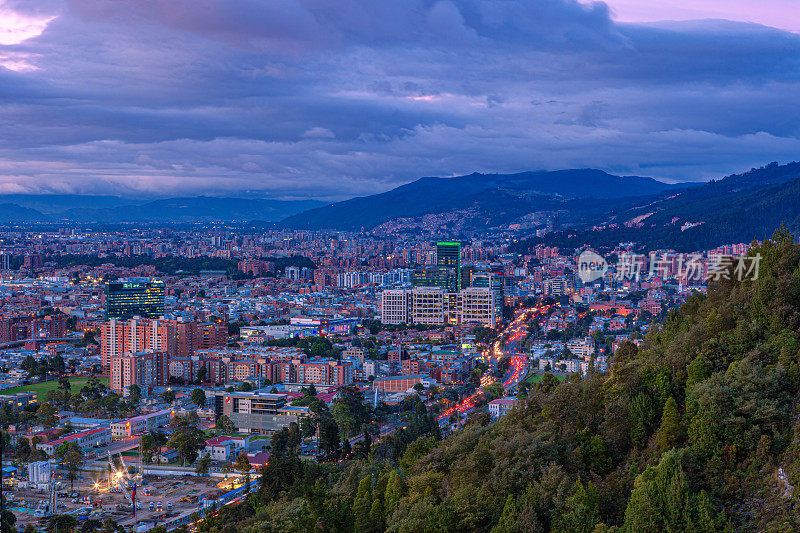 哥伦比亚波哥大-高角度全景Barrio De Usaquén在首都的日落后，从安第斯山脉的La Calera高地观看。